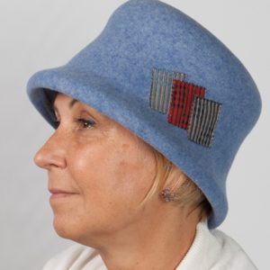 Side view of a light blue wool felt hat with patchwork detail to the side