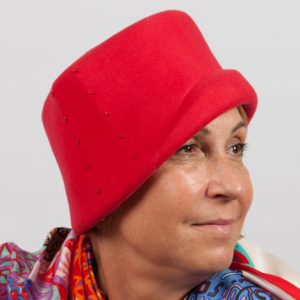 Side view of a red felt hat with bead design to the side