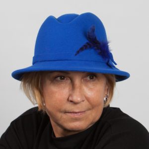 Front view headshot royal blue wool felt hat will small brim and indent on the top with navy feather the side.