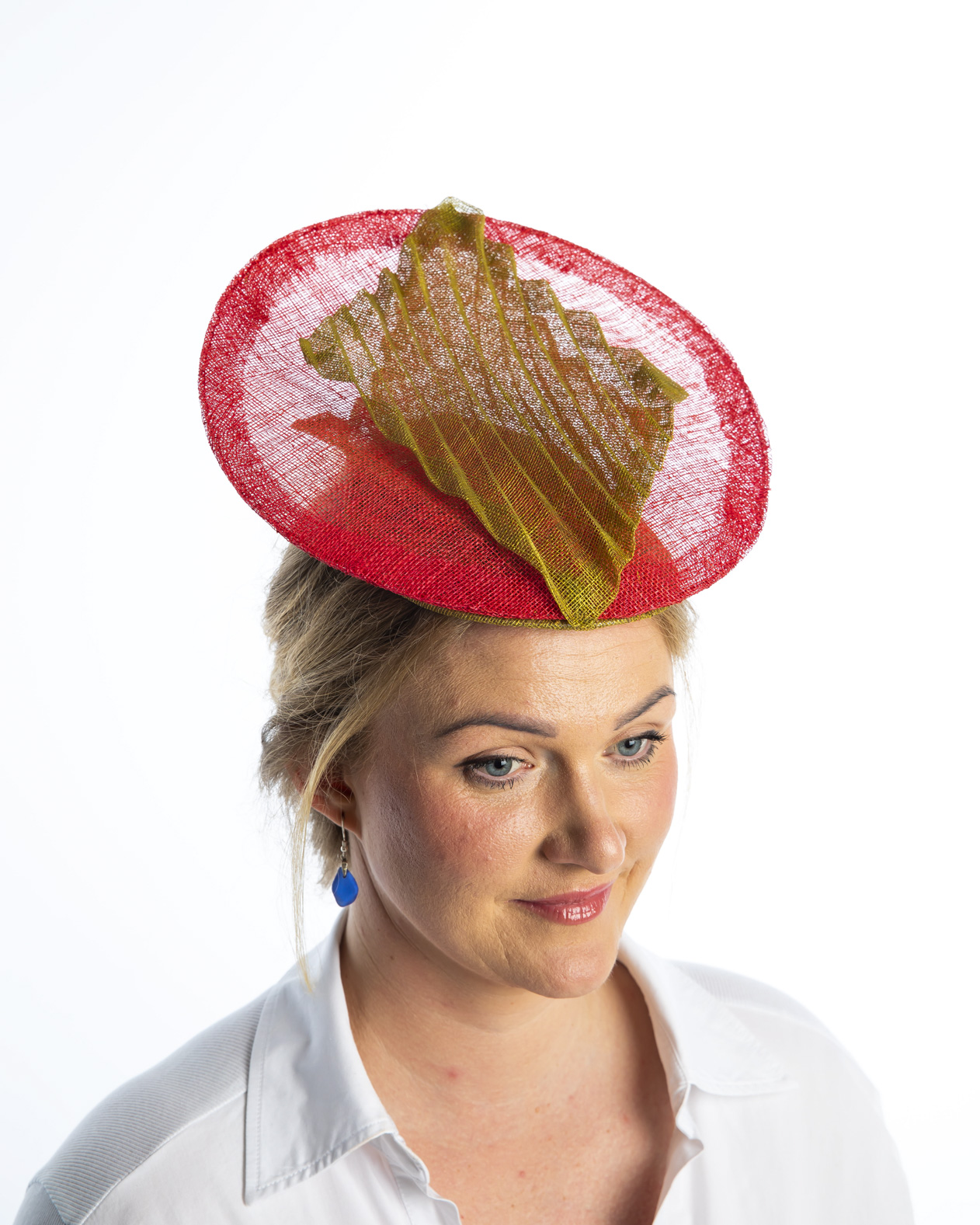 Front view of an orange hat with featherdetail worn to the side