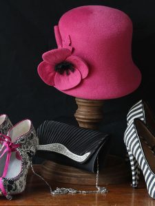 Front view of cerise bucket hat with cerise flower and black stamens.